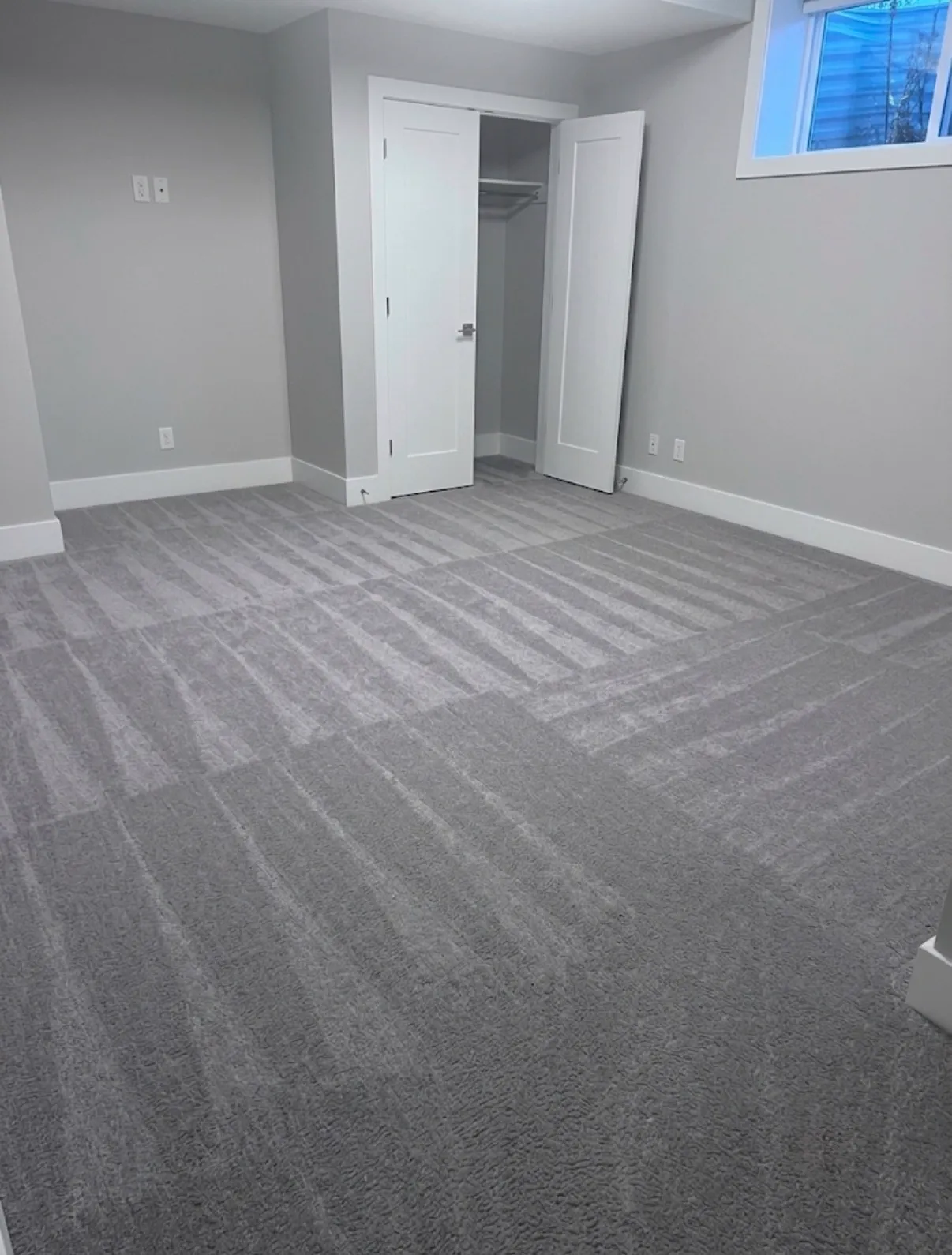 Empty room with freshly cleaned grey carpet, ready for a move-in